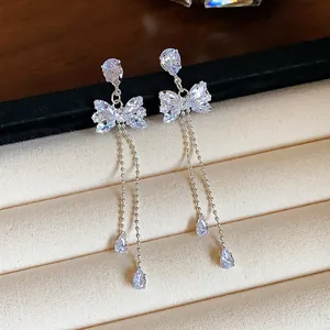 Detail shot of elegant zircon bowknot tassel earrings with delicate silver chains