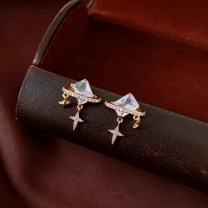 Détail de boucles d'oreilles vintage en or avec cristal carré et étoile sur boîte en cuir