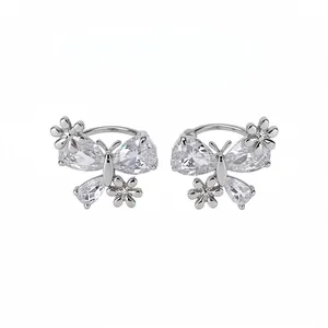 Elegant silver-toned butterfly and flower ear clips with clear cubic zirconia stones.