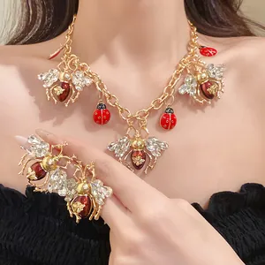 Detailed close-up of vintage insect necklace and earrings set with rhinestones and enamel