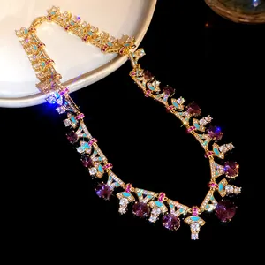 Nahaufnahme einer luxuriösen Goldkette mit lila Zirkonia und blauen Emaille-Verzierungen