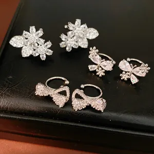 Sparkling silver-toned zircon ear clips with butterfly, flower, and bow designs