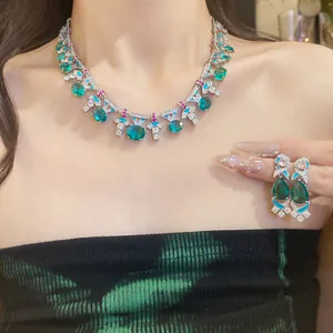 Elegantes Set aus Halskette und Ohrringen mit grünen Zirkonia an asiatischem Modell