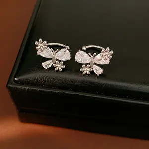 Close-up of sparkling zircon butterfly and flower non-pierced ear clips on black box