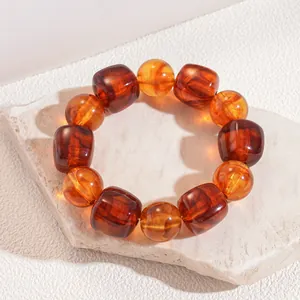 Close-up detail showing the vintage amber-toned round and cube beads of this acrylic bracelet