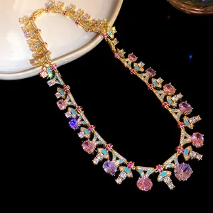 Detail einer vergoldeten Kette mit rosa Zirkonia und türkisfarbenem Emaille