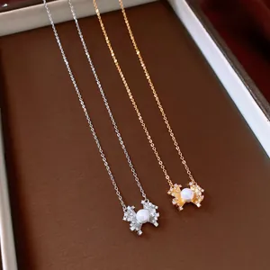 Primo piano elegante di collane con fiori, perla bianca e scintillanti zirconi cubici