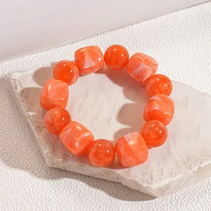 Detail view of orange marbled acrylic bracelet with alternating round and square beads