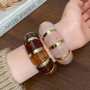 Gros plan de bracelets en résine géométriques irréguliers avec textures marbre et ambre