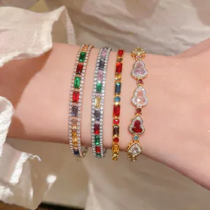 Nahaufnahme von vier bunten Zirkonia-Armbändern mit Herz- und Rechtecksteinen am Handgelenk