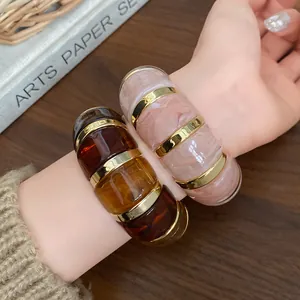 Gros plan de bracelets élastiques en résine géométrique en ambre et rose marbré chic