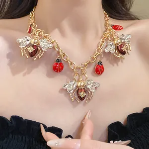 Detailed macro view of a vintage insect necklace featuring crystals and enamel charms