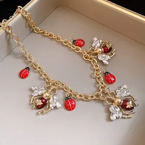 Close-up of vintage insect necklace featuring ladybug and rhinestone bee charms