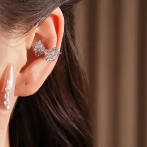 Detailed macro view of sparkling zircon bow ear cuff on model for non-pierced ears