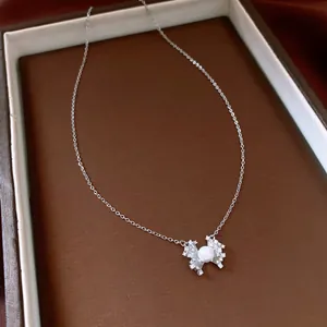 Dettaglio dell'elegante collana floreale con pendente in zircone e perla.