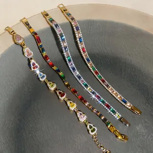 Detailansicht von bunten Zirkon-Herz- und Tennisarmbändern auf einer Keramikplatte