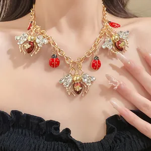 Close-up of a vintage insect necklace with bee and ladybug charms on a female model.