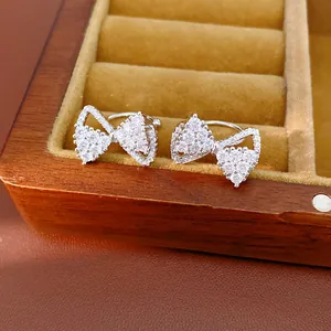 Exquisite macro detail of silver bow ear clips featuring sparkling pavé zircon stones