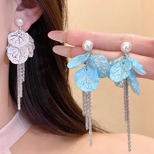 Detailed macro view of elegant pearl petal tassel earrings with long silver chains