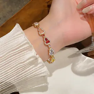 Detailansicht eines luxuriösen Armbands mit bunten Zirkonia-Herzen in Goldoptik für Damen