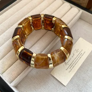 Vue détaillée d'un bracelet élastique de luxe en résine ambrée et métal doré