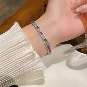 Nahaufnahme eines Regenbogen-Zirkonarmbandes am Handgelenk mit elegantem Hintergrund