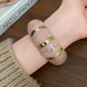 Bracelet extensible géométrique en résine avec accents dorés porté au poignet