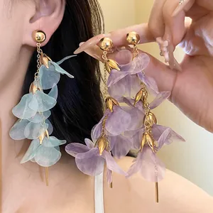 Detailed view of handmade flower mesh tassel earrings in light blue and purple tones