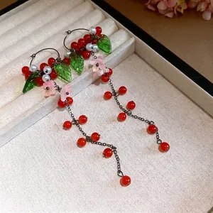 Elegante lange Quastenohrringe mit Harzblumen, grünen Blättern, Perlen und roten Perlen