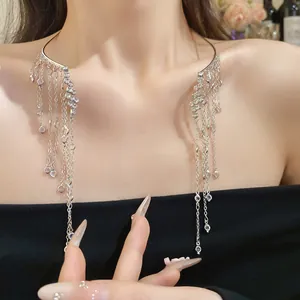 Détail d'un collier ras du cou argenté avec de longues franges en strass sur un mannequin.