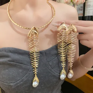 Detailed view of vintage gold fishbone necklace and earrings with pearl drops