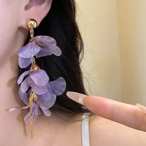 Detail of purple floral mesh tassel earrings worn on ear showing delicate petals