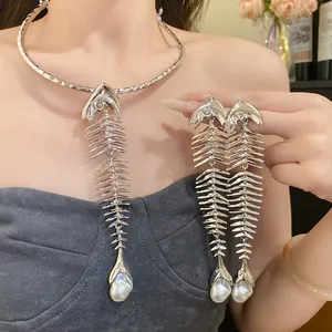 Detailed view of a vintage silver fishbone necklace and earring set with pearls on a model