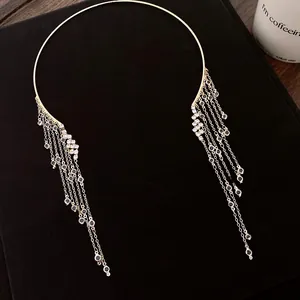 Vue détaillée d'un collier ras du cou doré avec des glands en strass brillants