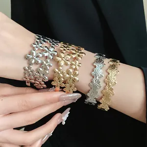 Close-up of gold and silver metal flower open bangles on wrist, vintage style details