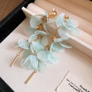 Detailed macro view of mint green mesh flower petal earrings with golden chain tassels