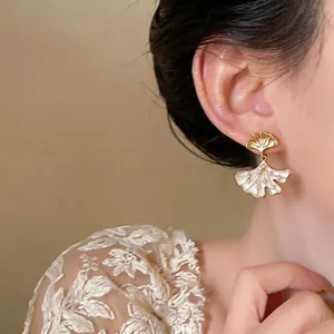 Elegant 14k gold plated ginkgo leaf zircon earrings shown on a model for a luxury look