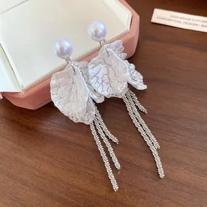 Detailed view of elegant white petal earrings with silver tassels and pearls