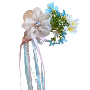 Balletcore style hair clip featuring cream fabric flowers and long pastel pink and blue ribbons