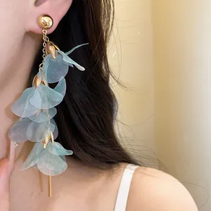 Close-up of elegant mint green mesh flower tassel earrings showing delicate texture.