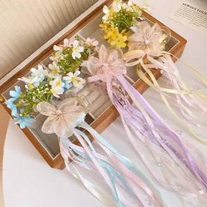 Detailed view of ballet style floral hair clips with long colorful ribbons in a box