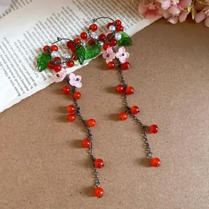 Detailansicht der roten Beeren-Quastenohrringe mit Harzblättern und Blumen