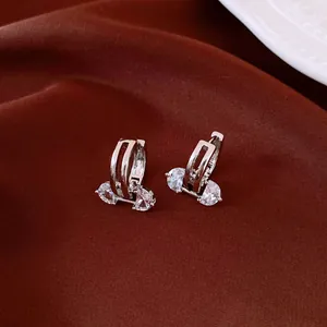 Elegant 18K gold plated hollow oval earrings with sparkling zircon stones on silk backdrop