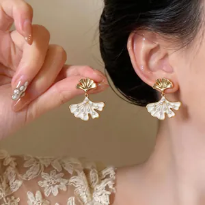 Detailed view of 14k gold-plated ginkgo leaf earrings with sparkling zircons