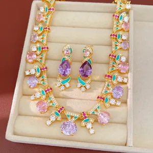 Vista detallada de conjunto de joyas de estilo corte con circonitas y esmalte de color.