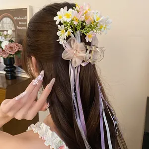 Detailed view of floral hair claw clip with elegant ribbons in a side bun hairstyle