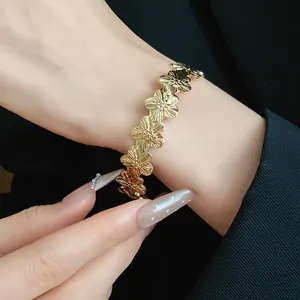 Detail view of a vintage gold-toned metal bracelet with intricate flower designs