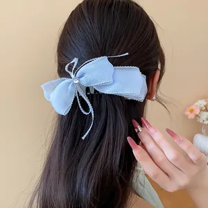 Vista trasera de una pinza para el cabello con lazo de encaje azul y detalle de corazón