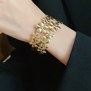 Exquisite detail of a gold-tone double-layer floral cuff bracelet worn on a wrist