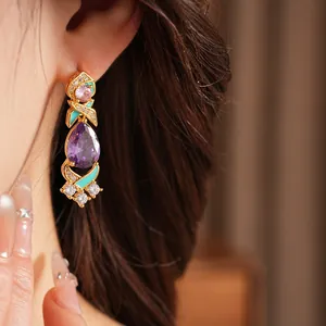 Detalle de pendiente de estilo palaciego con circón morado y esmalte turquesa.